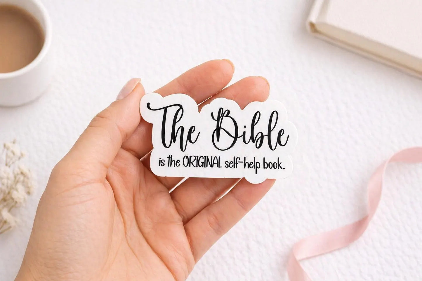 Hand holding Christian Bible journaling sticker for size referen
