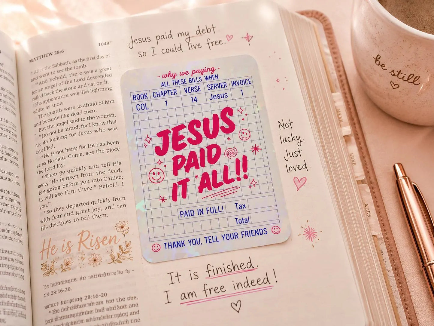 Christian Jesus Paid It All sticker beside an open Bible and journal