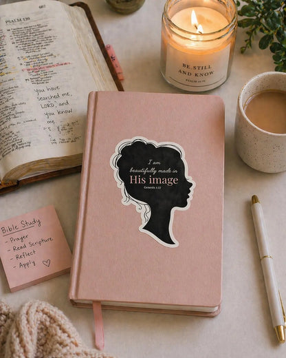 Christian Bible verse sticker on blush journal beside an open Bible and candle