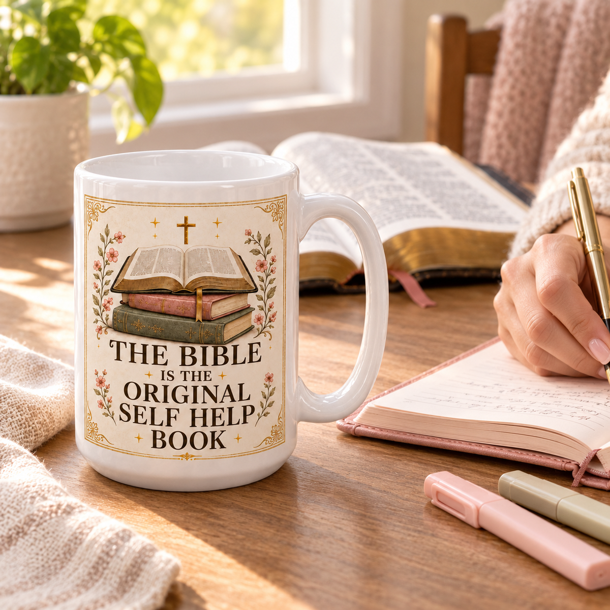 Bible study mug beside an open Bible while a woman writes in a blush prayer journal